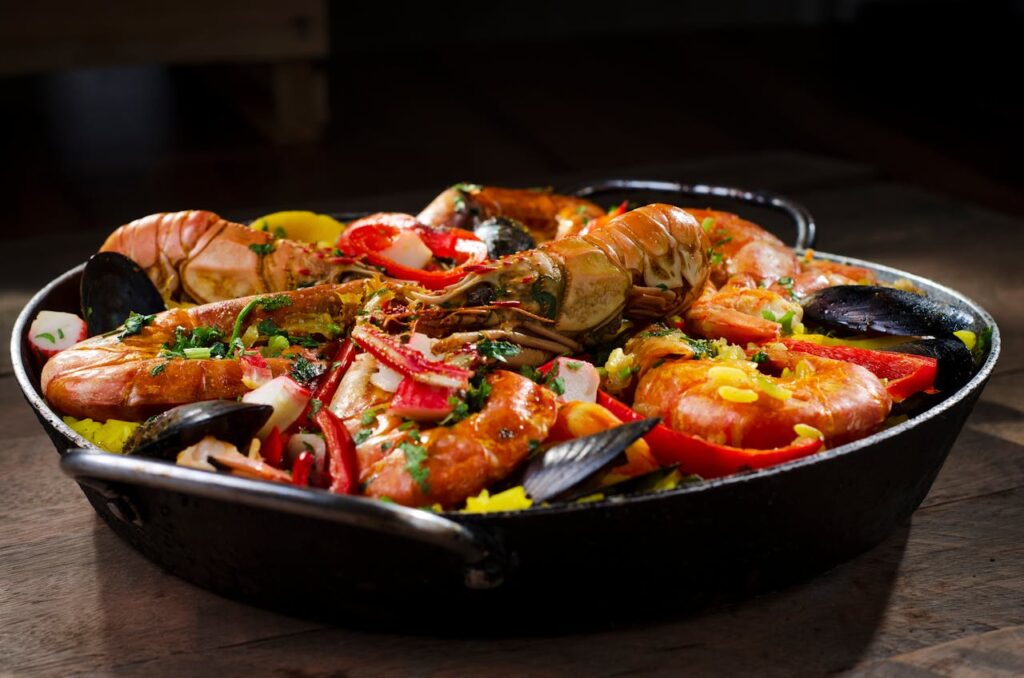 Traditional Spanish paella with saffron-infused rice, seafood, and vegetables in a rustic pan.