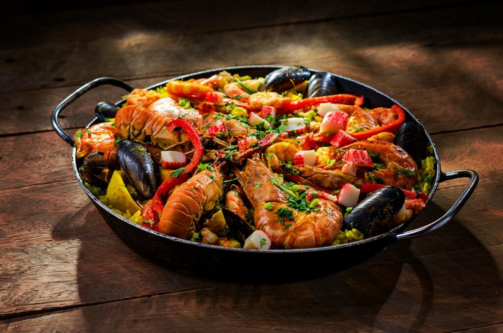 Traditional Spanish paella with saffron-infused rice, seafood, and vegetables in a rustic pan.